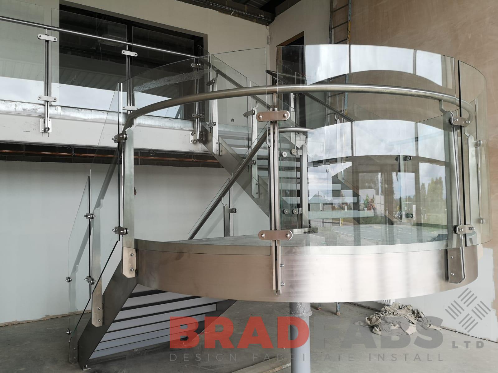 Bespoke Stainless steel curved staircase frame with infinity glass balustrade by Bradfabs 