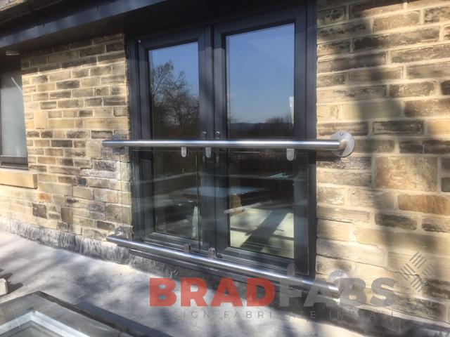 Modern Juliette balcony with glass balustrade and stainless steel top and bottom rail by Bradfabs 