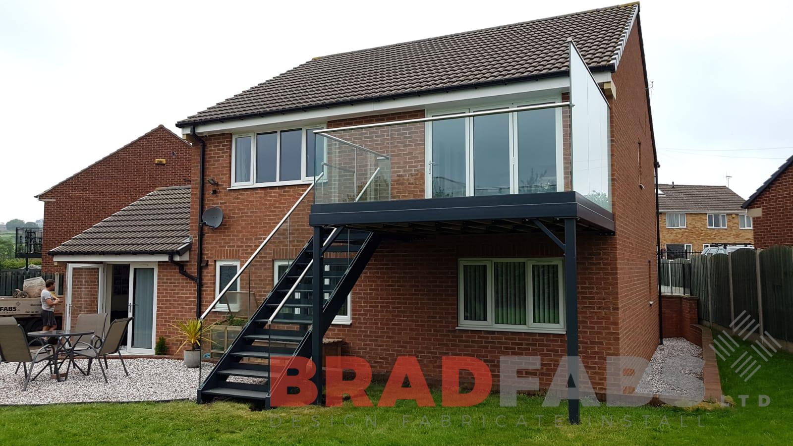 Bespoke designed metal and glass balcony with straight staircase by Bradfabs