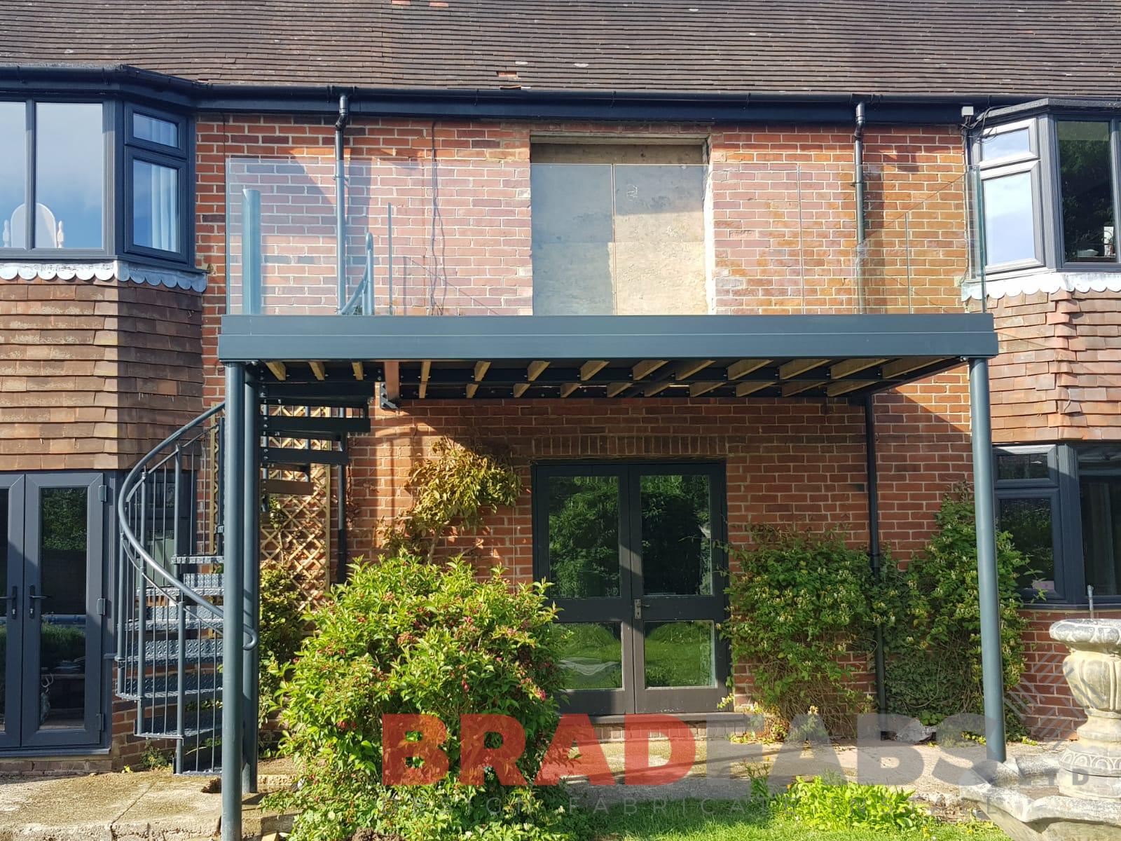 Stunning glass and steel balcony with spiral staircase designed by Bradfabs