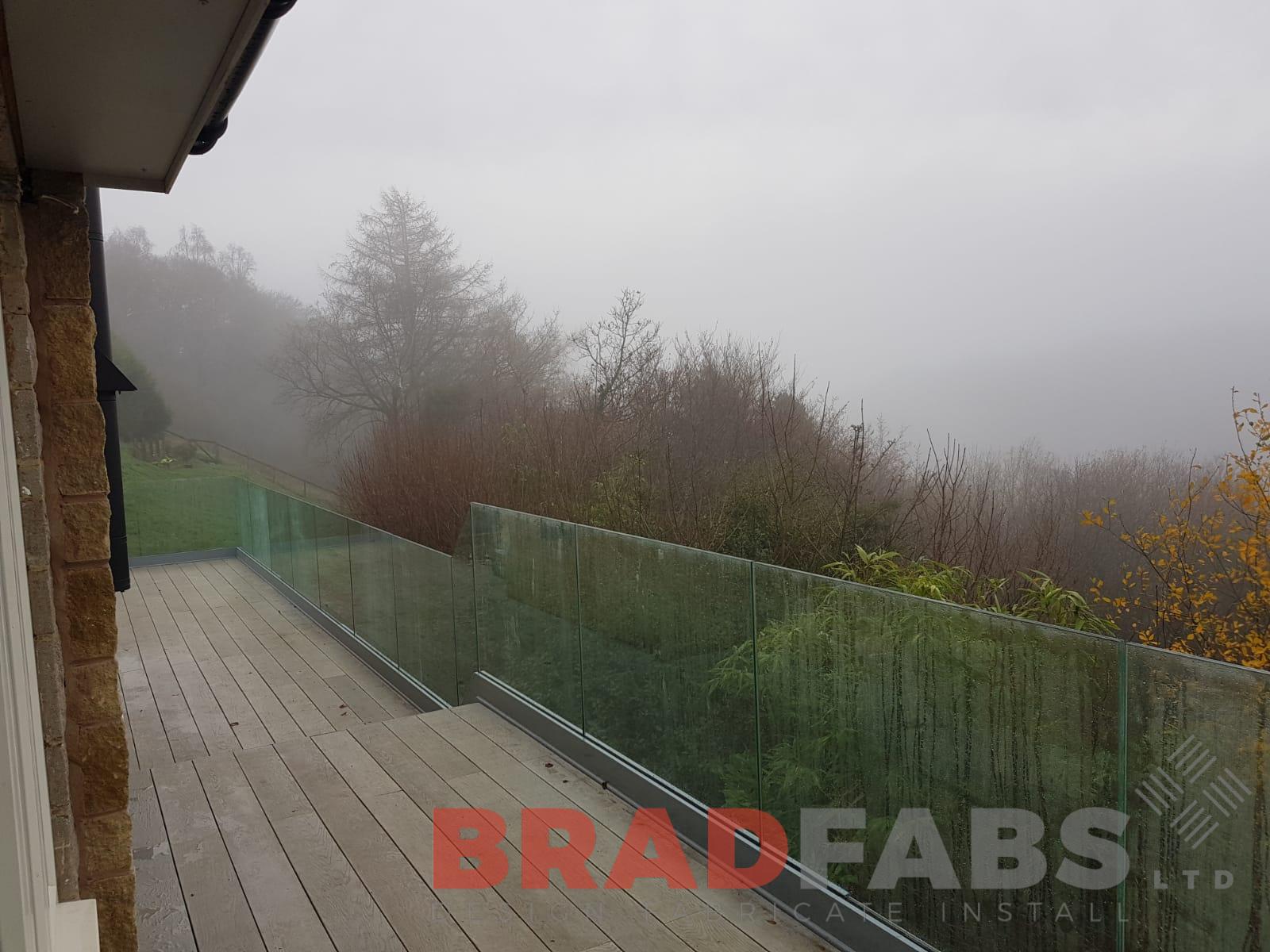 Beautiful modern balcony with infinity galss balustrade and milboard decking by Bradfabs UK LTD 