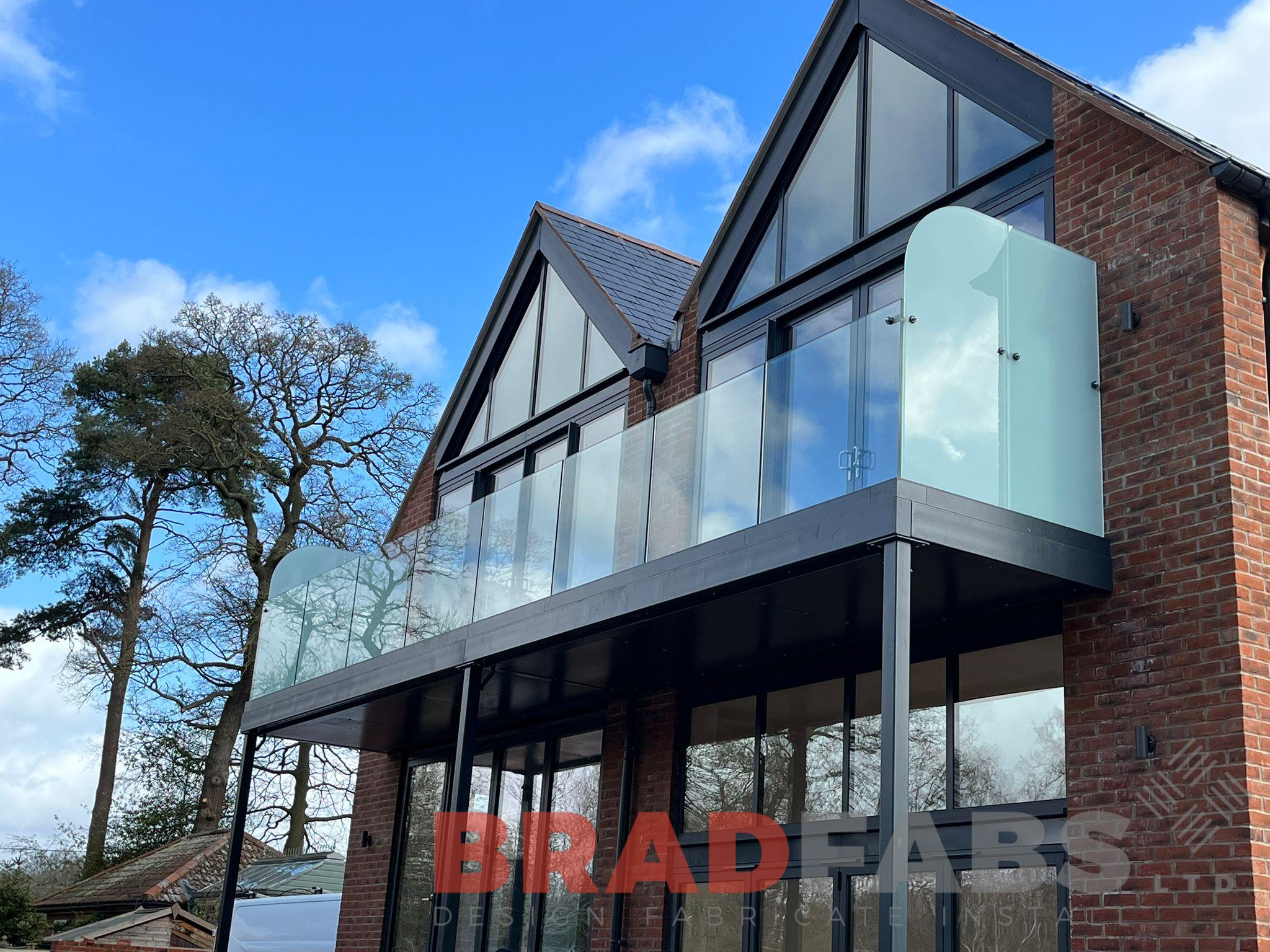 Long glass balcony with privacy screen and three support posts by Bradfabs