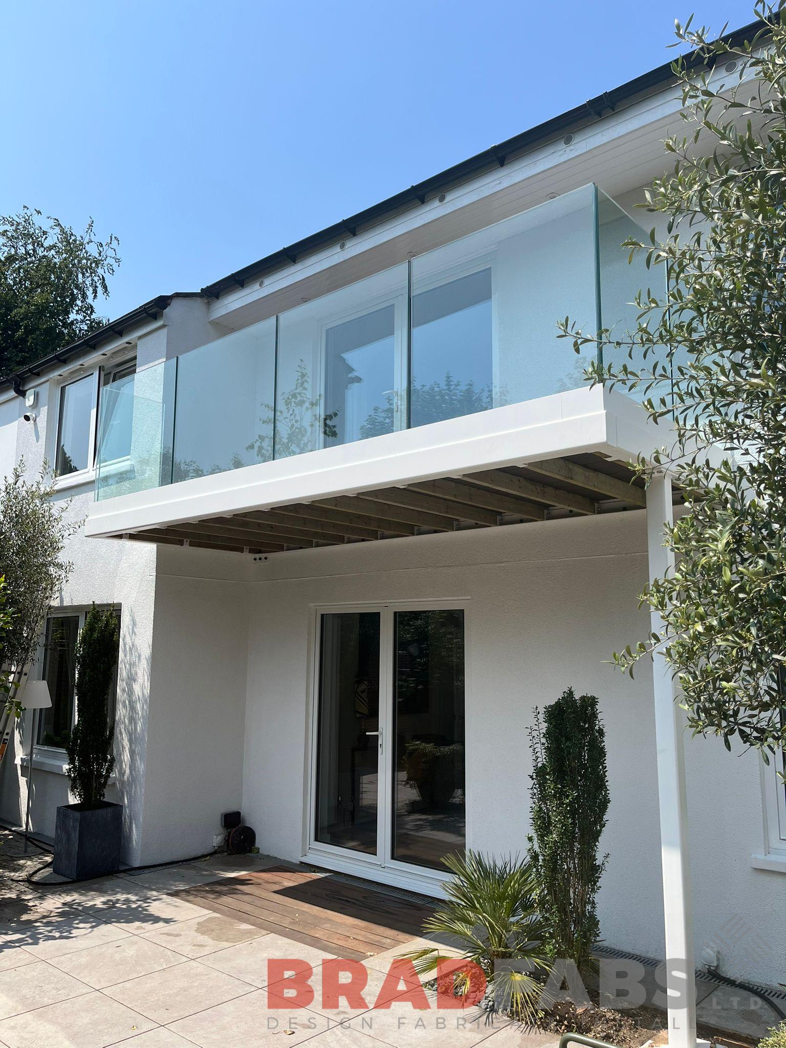 Steel balcony with frameless glass balustrade and one support leg by Bradfabs 