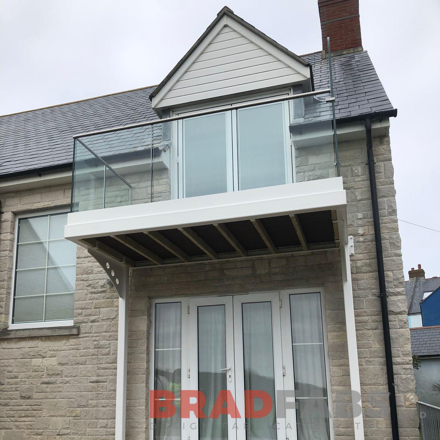 Cantilevered balcony with legs running down the wall complete with floating glass