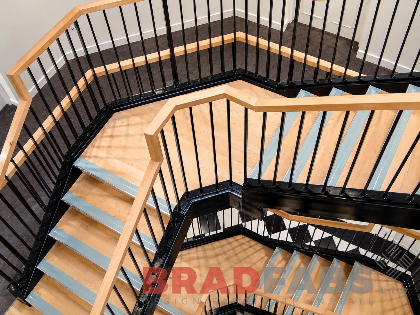 Commercial steel staircase with black powder-coated balustrades, timber handrails and multiple feature landings.