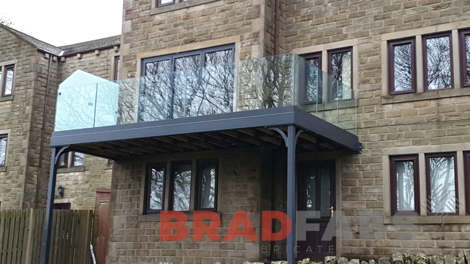 mild steel channel system balustrade with infinity glass balustrade with privacy screen to one side on a balcony with two supporting legs by Bradfabs Ltd 