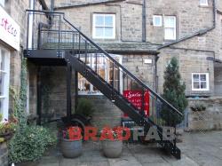 Access staircase to first floor shop within a courtyard area.
