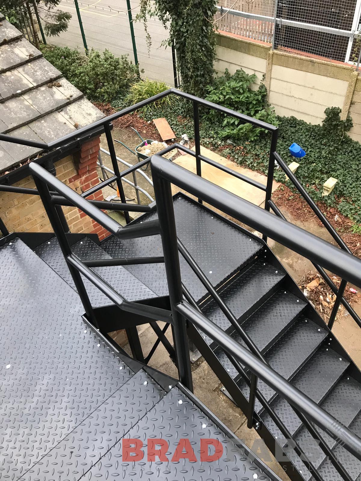 External Fire Escape straight staircase manufactured in mild steel, galvanised and powder coated in black with mid and top rail balustrade and durbar treads by Bradfabs for a school
