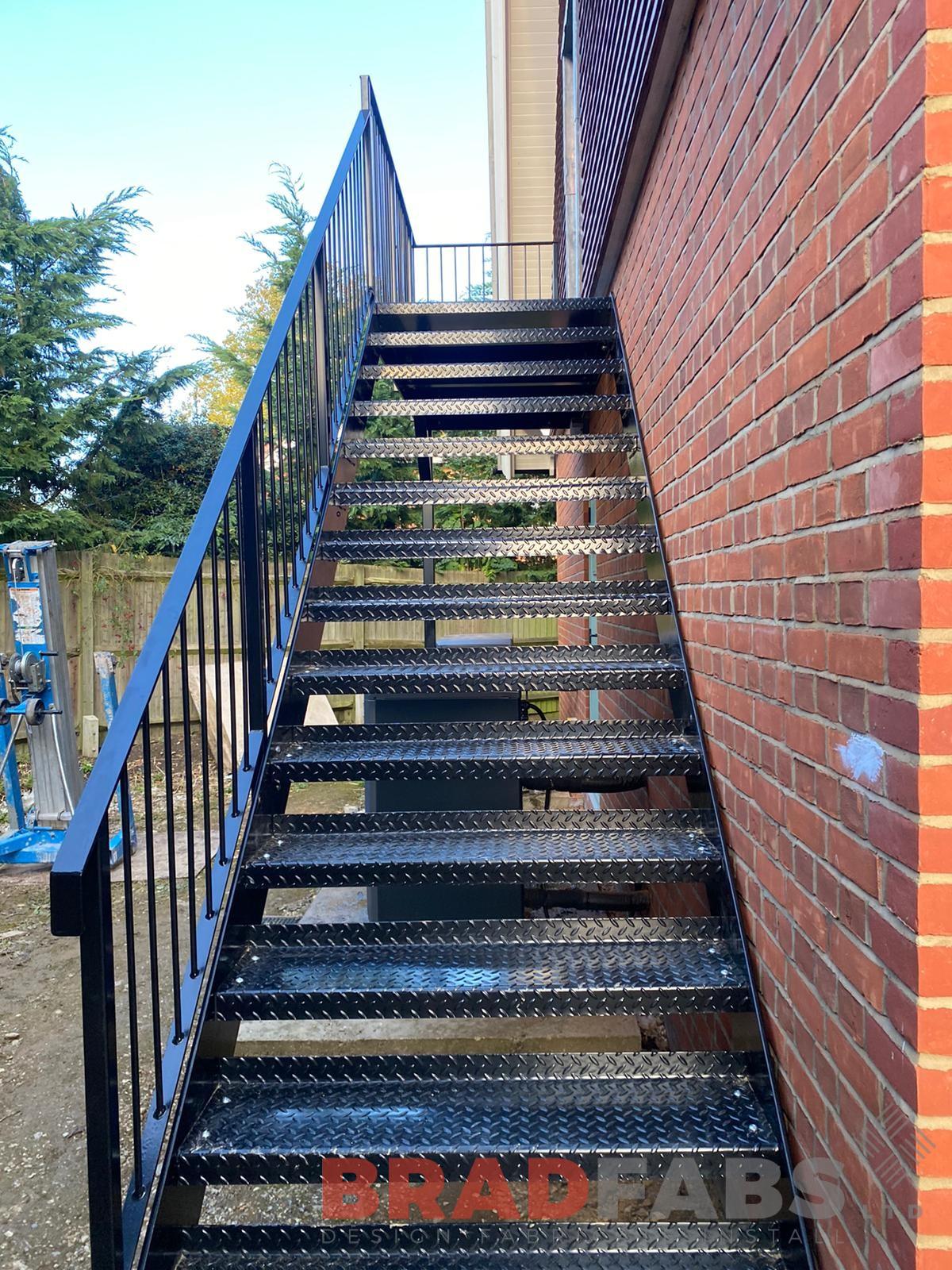 External steel staircase, galvanised and powder coated black, with vertical bar balustrade and tubular top rail and complete with durbar treads by bradfabs 