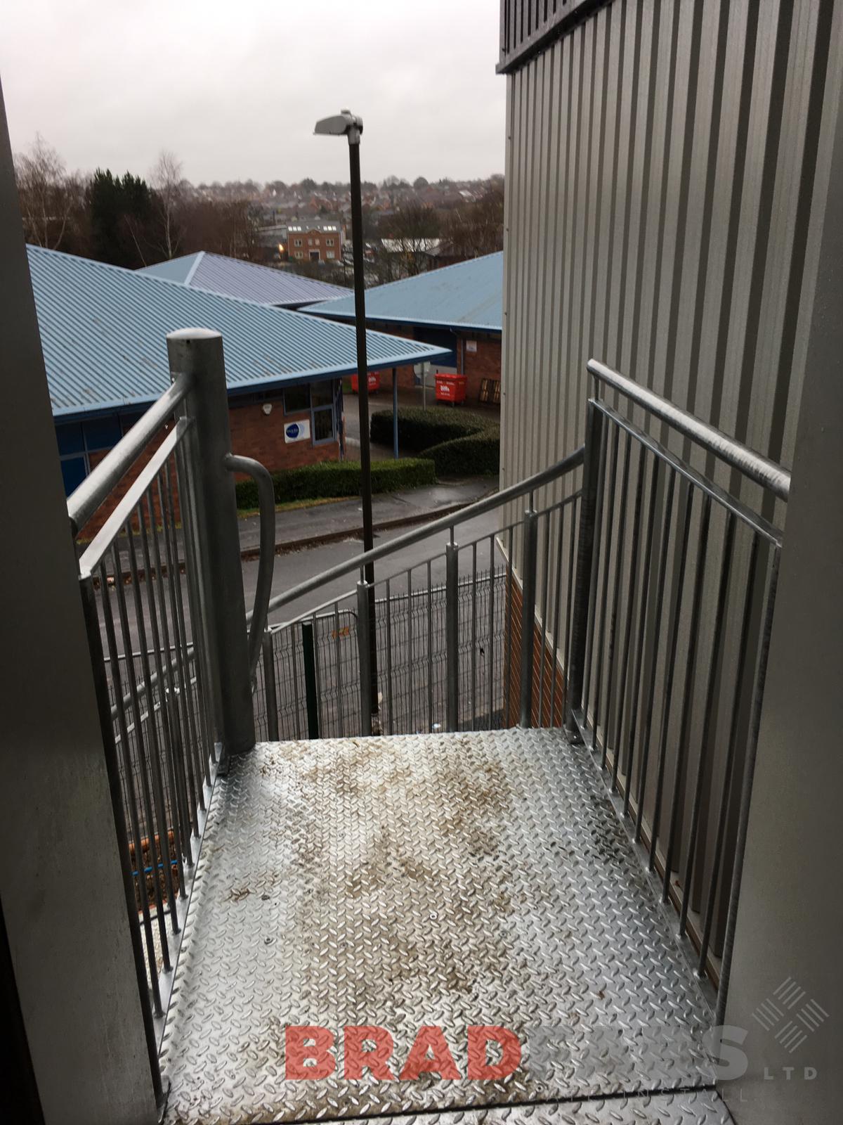 landing at the top of a bespoke spiral fire escape, manufactured in mild steel and galvanised with durbar treads by Bradfabs Ltd 