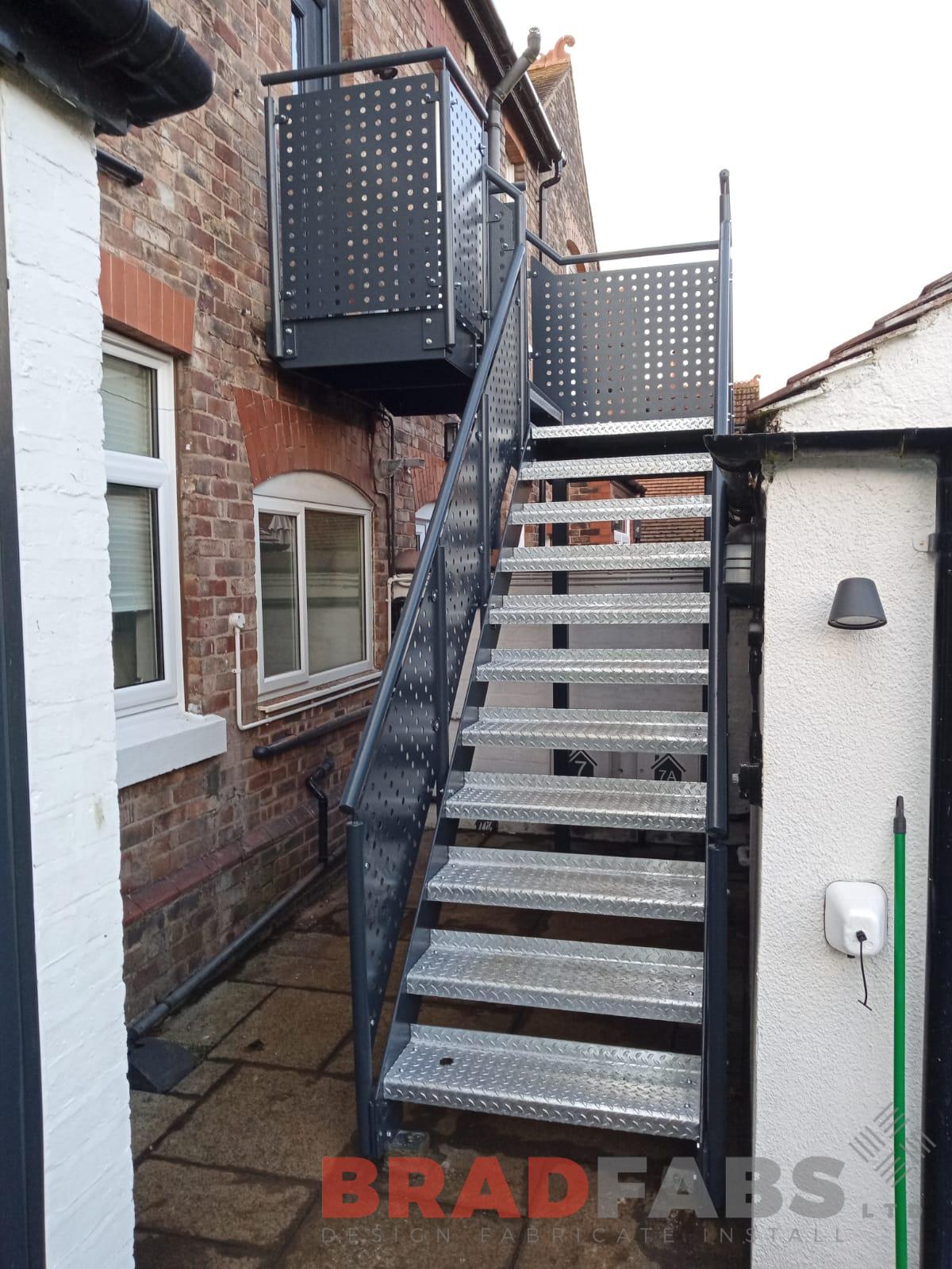 External steel staircase manufactured in mild steel, galvanised and powder coated with laser cut perforated infill panel balustrade by Bradfabs