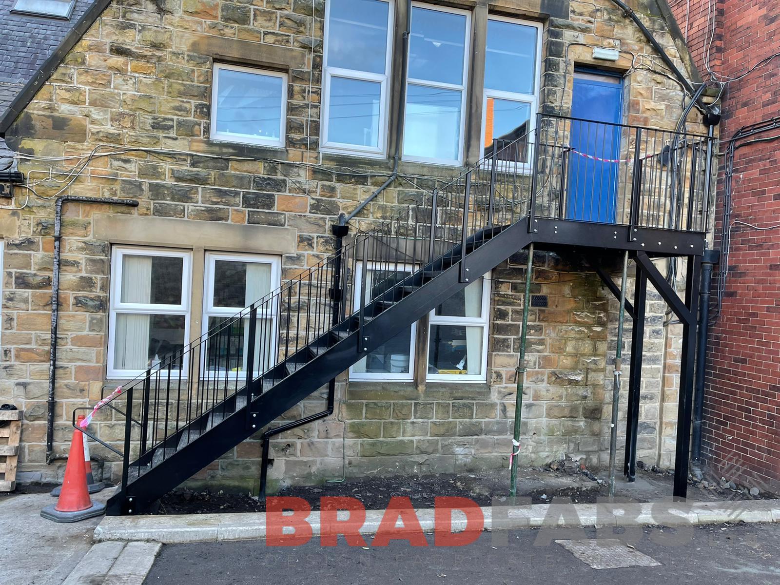 External staircase for a school, manufactured in mild steel, galvanised and powder coated black, with vertical bar balustrade and complete with durbar treads by Bradfabs