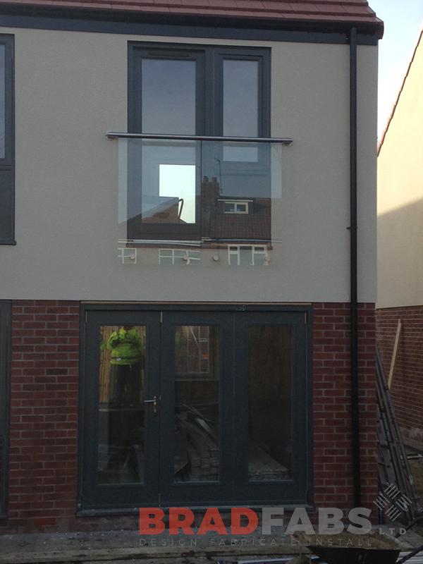 Modern Juliette balcony. Glass balustrade. Stainless steel rail.