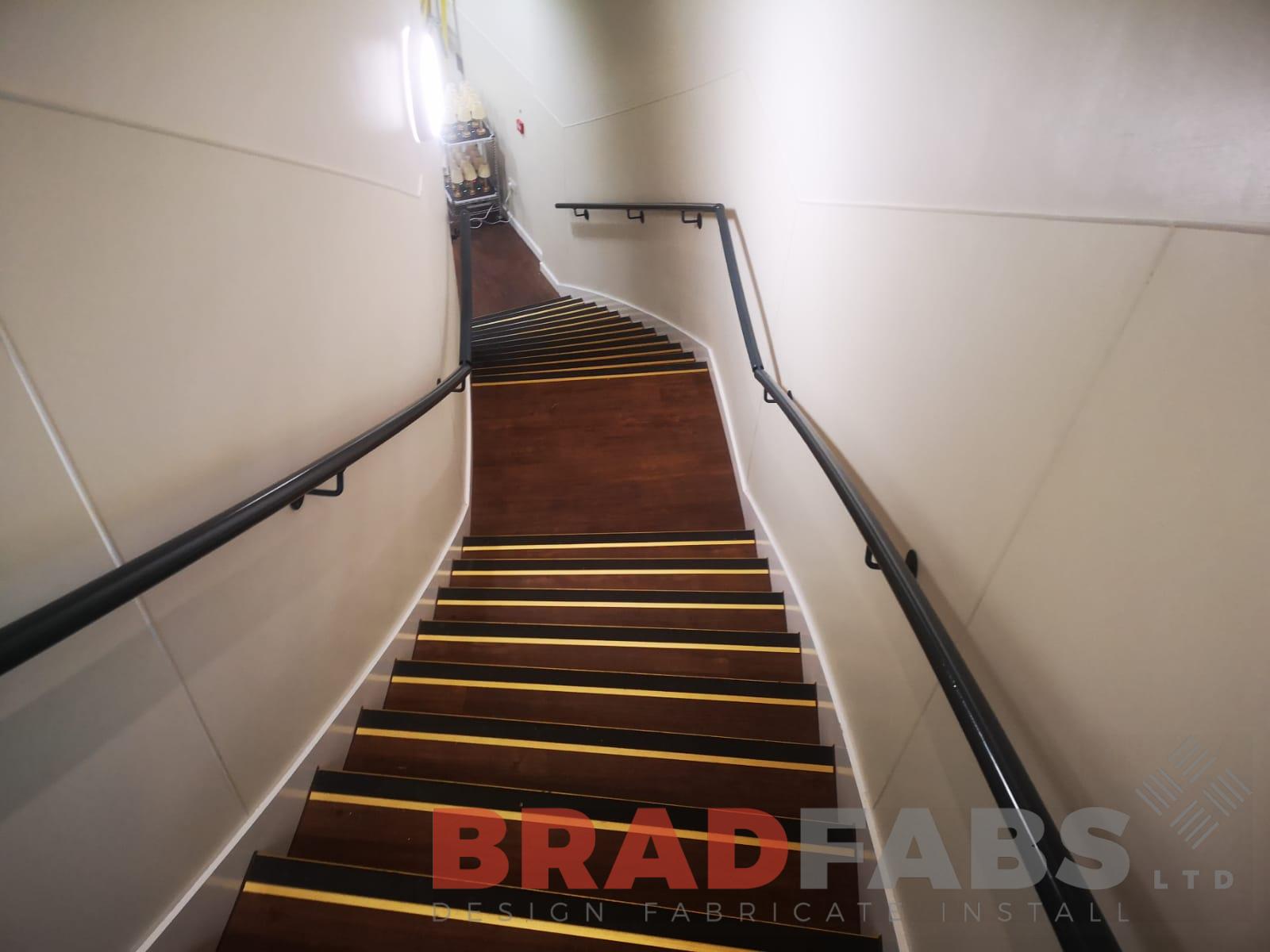 curved staircase with mild steel and powder coated wall mounted handrails to either side by Bradfabs Ltd 