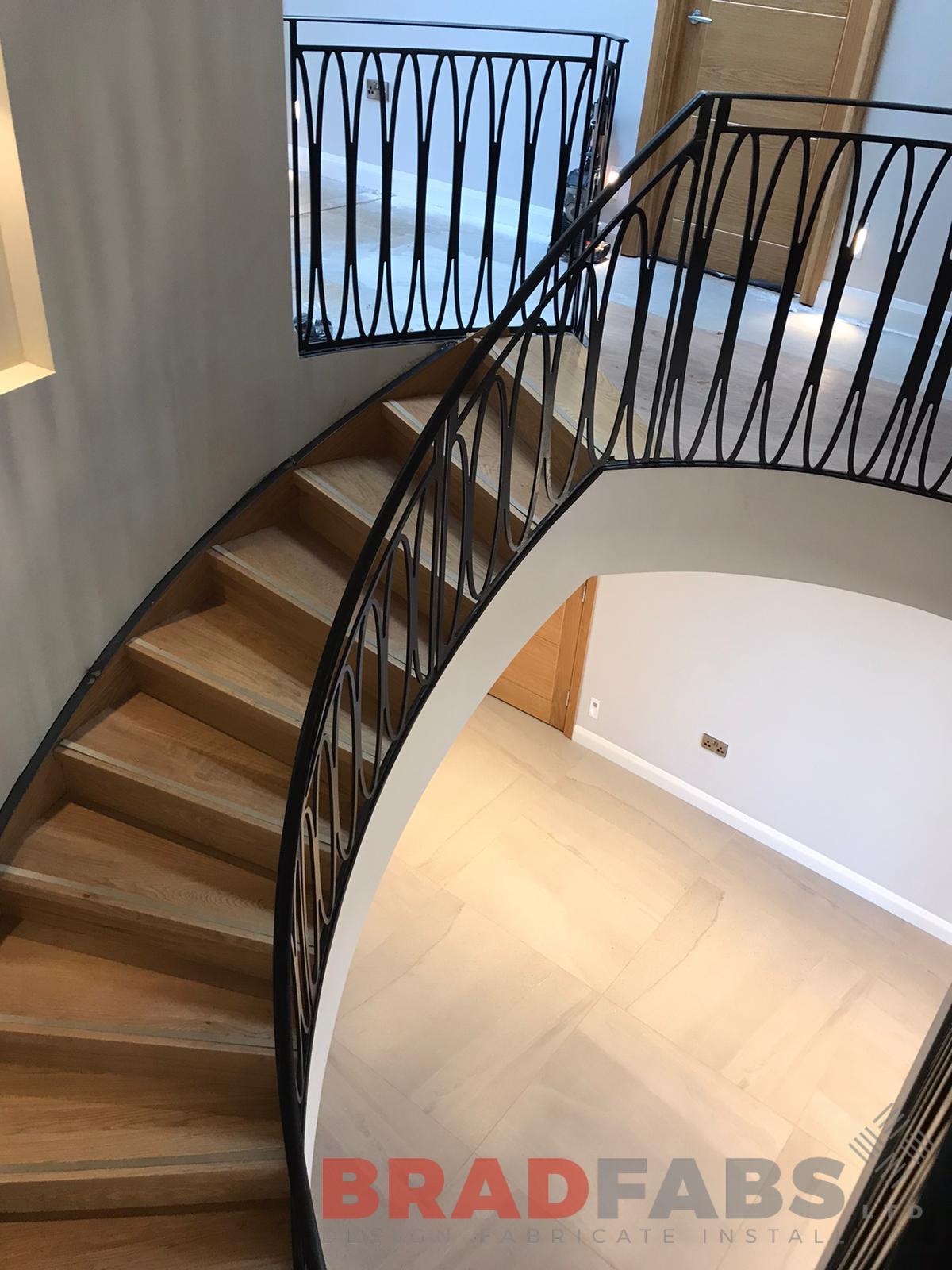 helix staircase with laser cut feature balustrade in mild steel and powder coated, with matching landing balustrade by Bradfabs