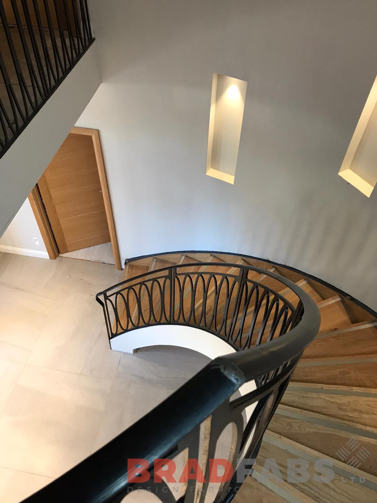 Bespoke internal helical staircase for a domestic property with laser cut feature balustrade in mild steel and powder coated black by bradfabs