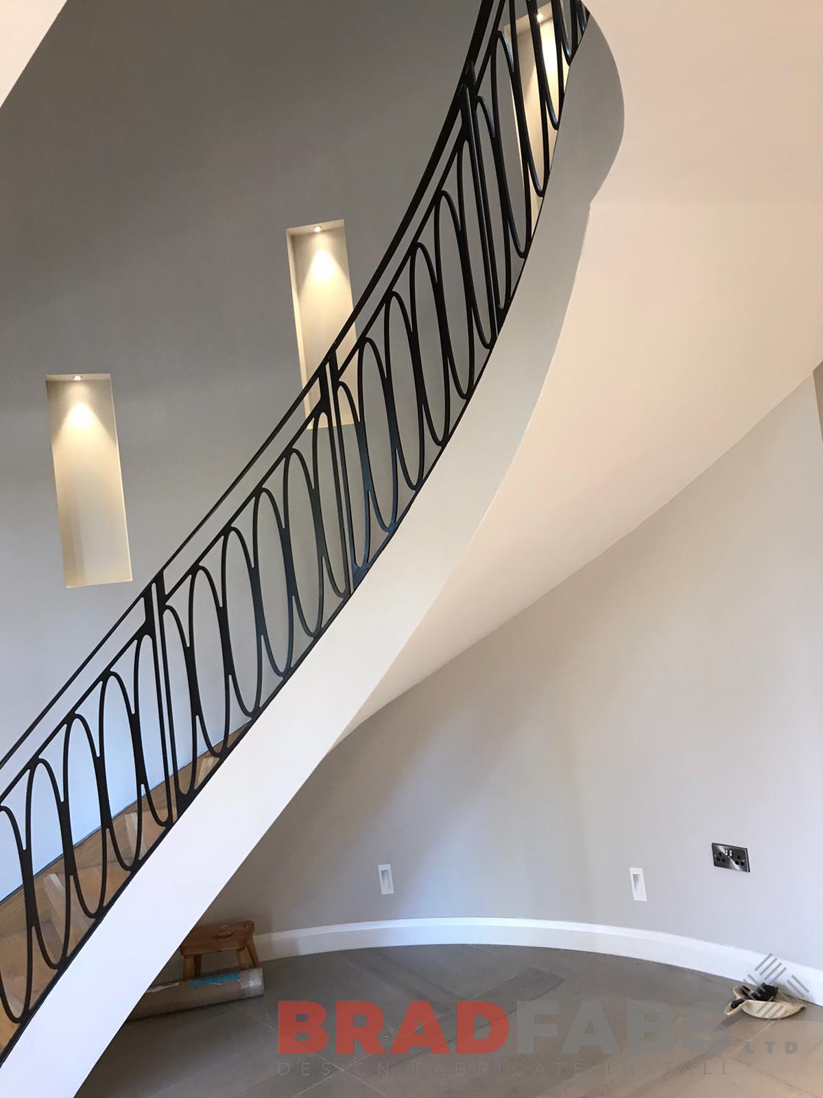 Bespoke helical staircase, laser cut feature balustrade matching the landing at top of staircase too, with oak treads and stainless steel insert, with veneer stringer by Bradfabs Ltd 