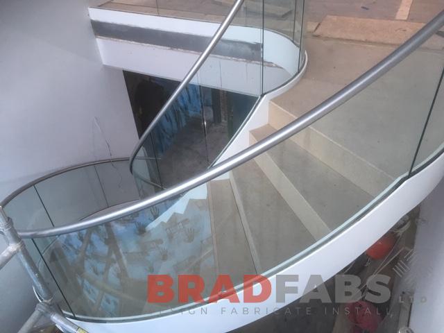 View from the side of the internal helical staircase with infinity glass and stainless steel top rail by Bradfabs 