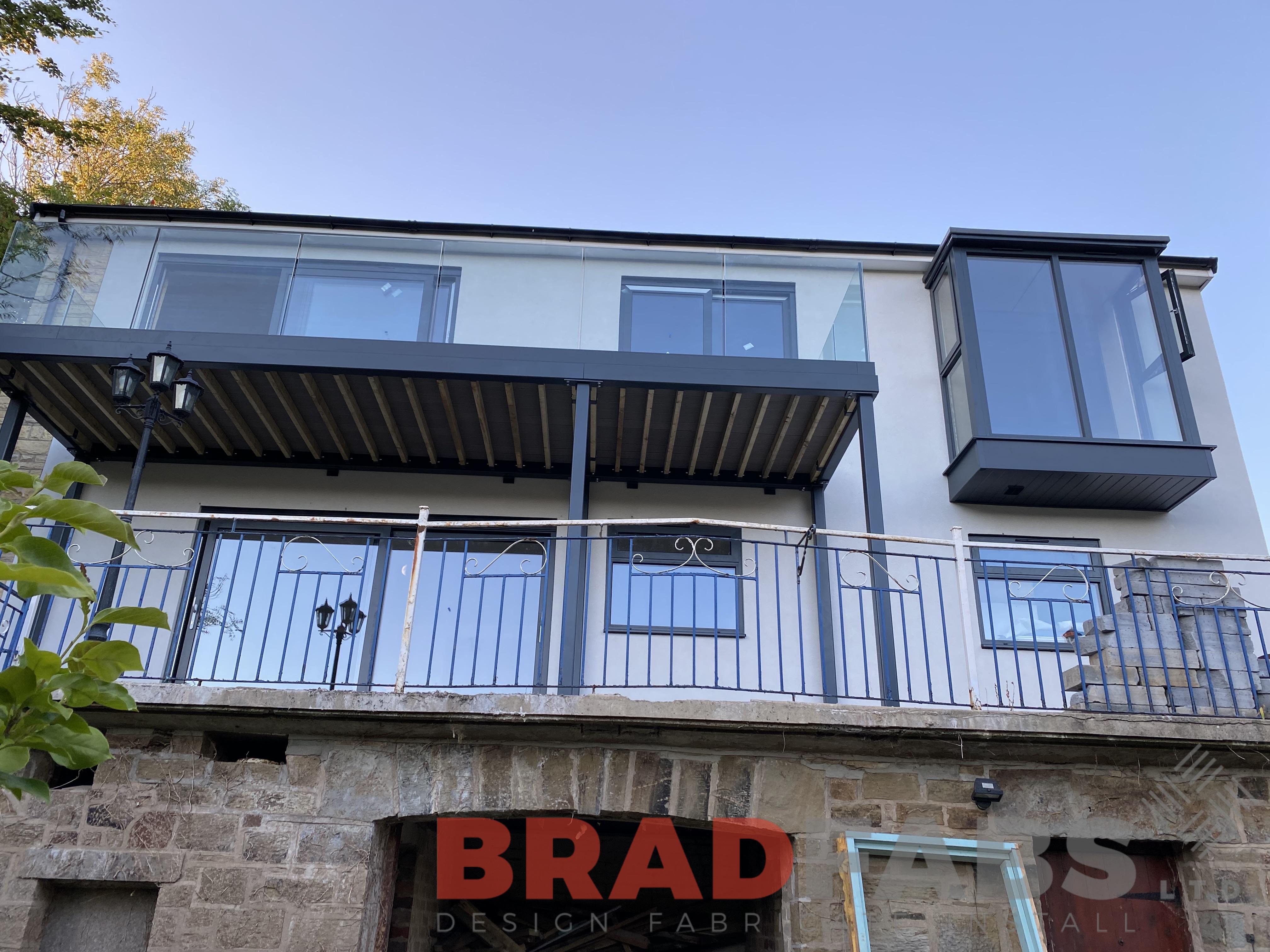 New bespoke steel balcony with six supporting legs and channel system infinity glass complete with composite decked flooring by bradfabs 
