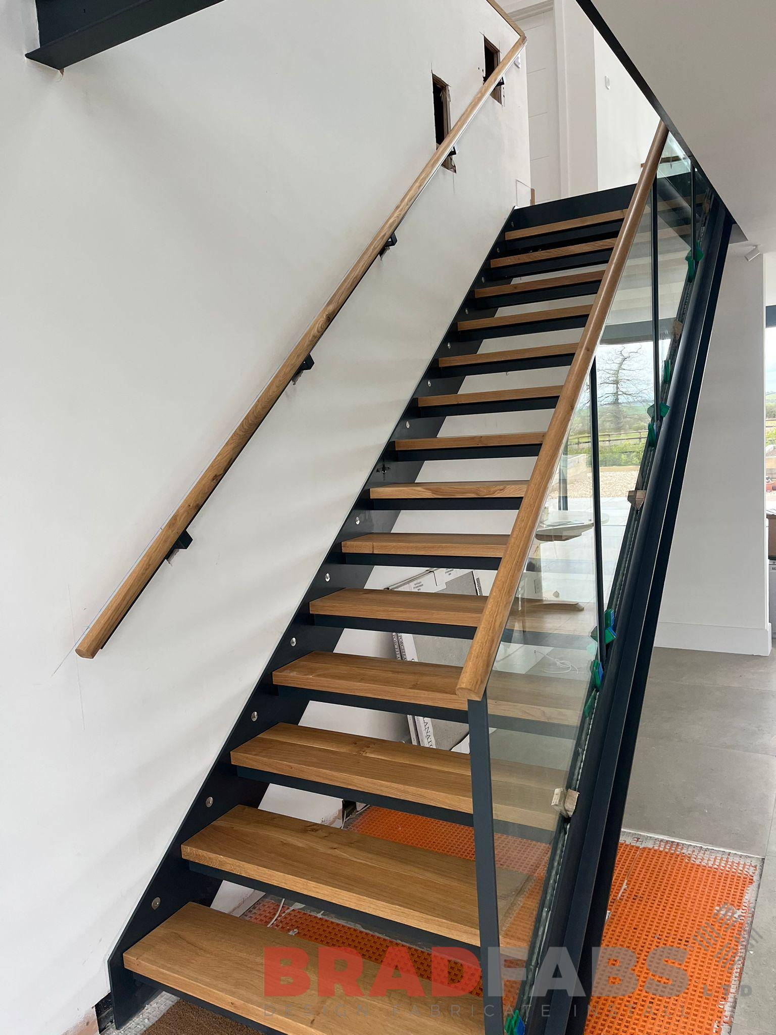 Internal staircase with glass balustrade and oak top rail by Bradfabs 