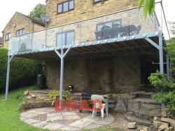 long balcony with four supporting legs and face fixed glass balustrade 