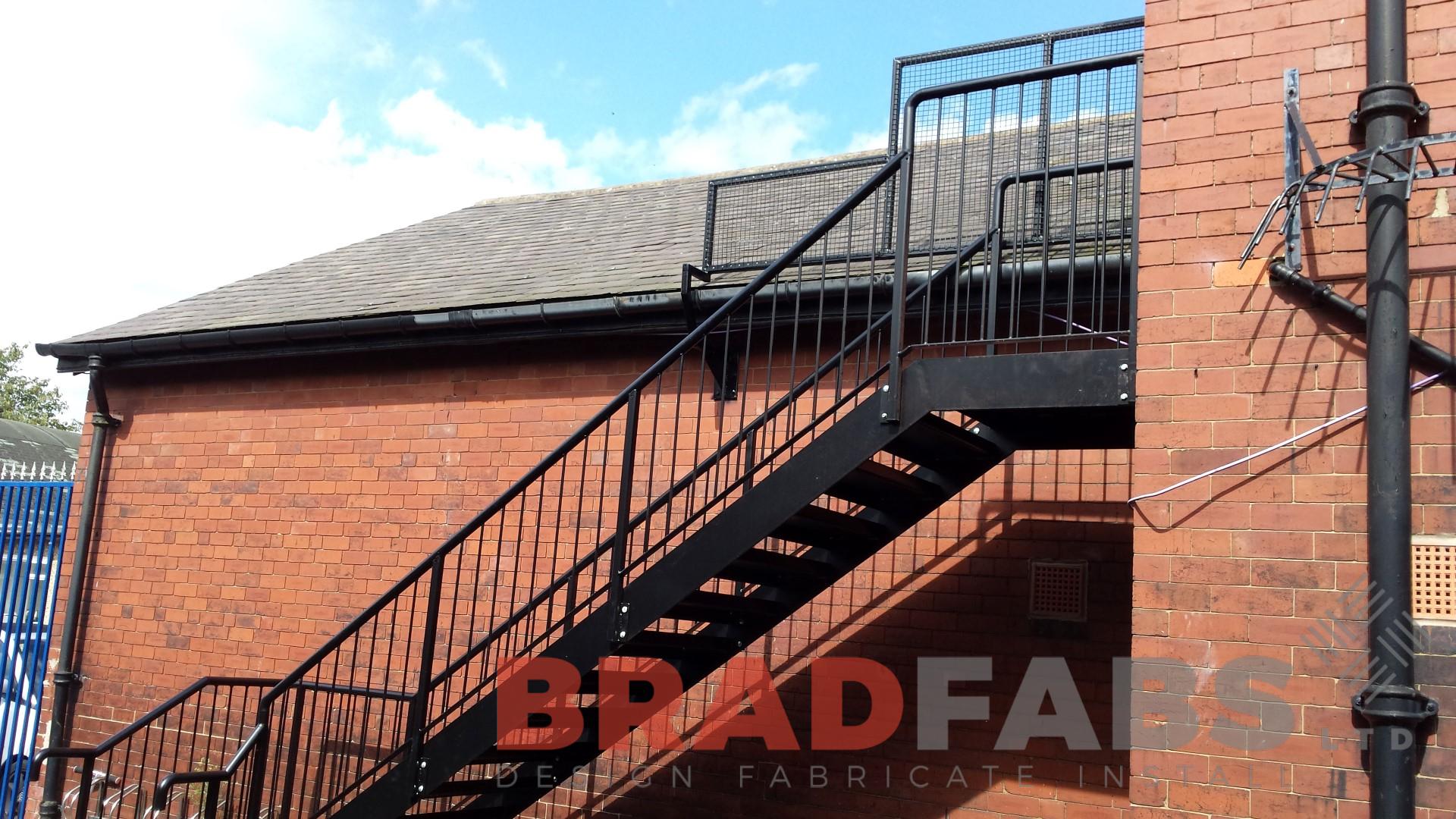 External steel staircase for a school building manufactured in mild steel, galvanised and powder coated with vertical bar balustrade and tubular top rail complete with durbar treads by bradfabs 