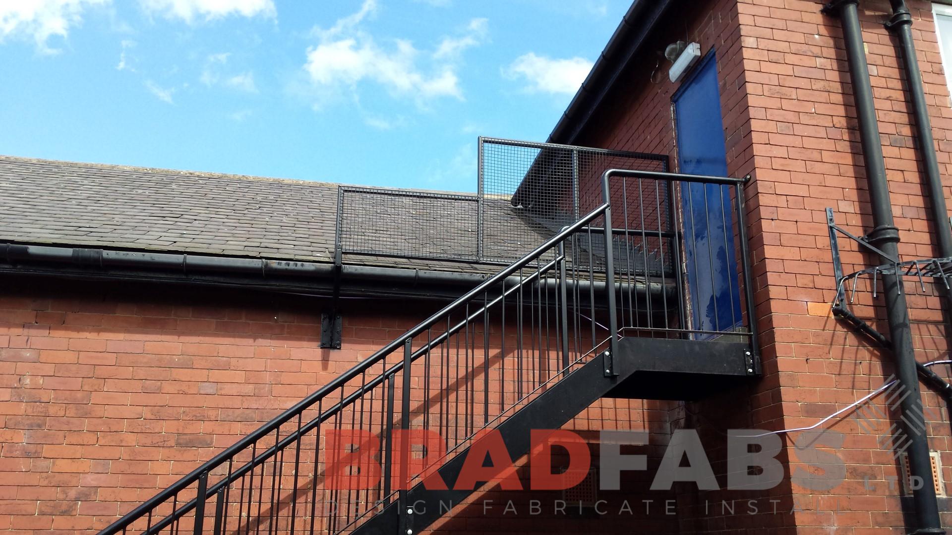 External steel staircase for a school building manufactured in mild steel, galvanised and powder coated with vertical bar balustrade and tubular top rail complete with durbar treads by bradfabs 
