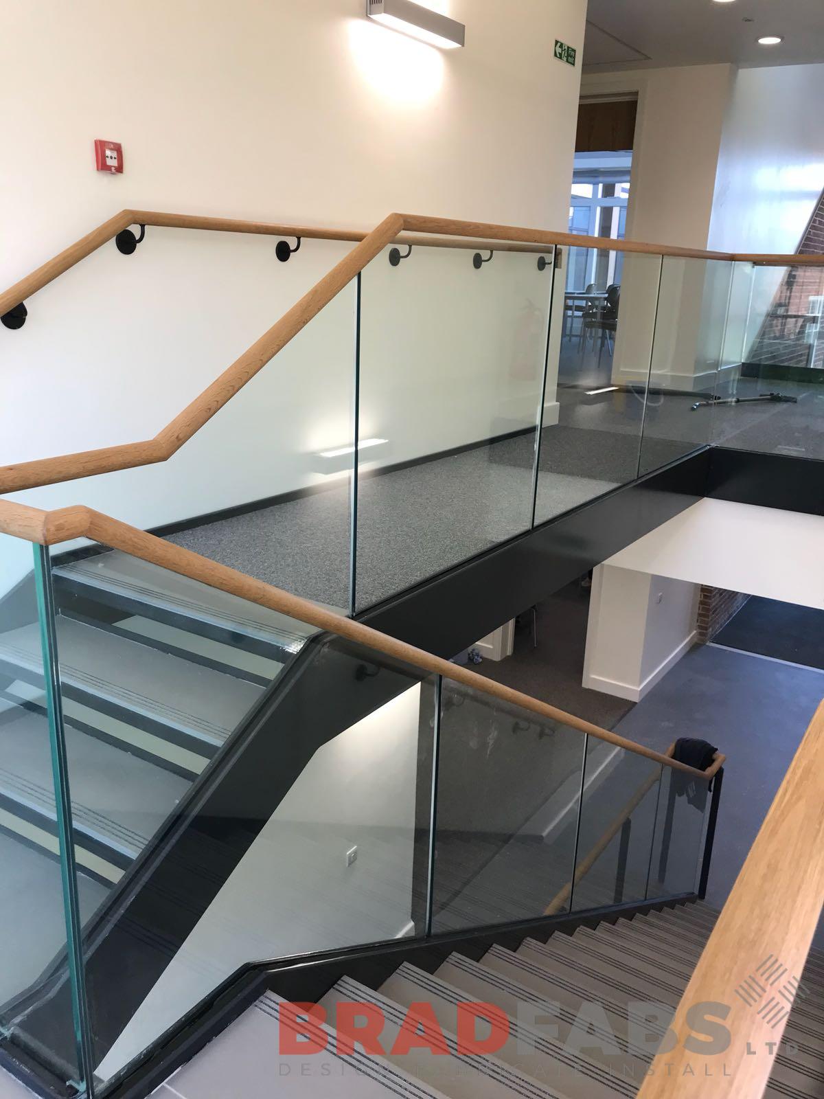 School staircase with glass balustrade and wooden handrail installed by UK based comany Bradfabs