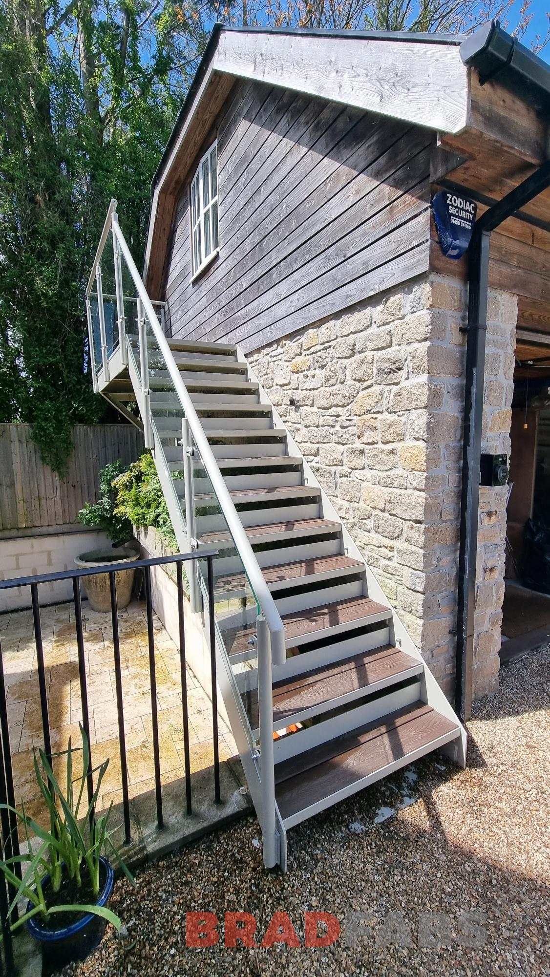 External straight staircase with glass balustrade and composite treads by bradfabs