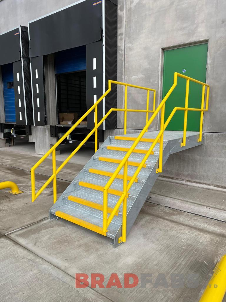 External steel staircase with yellow balustrade and yellow nosings on the durbar treads 