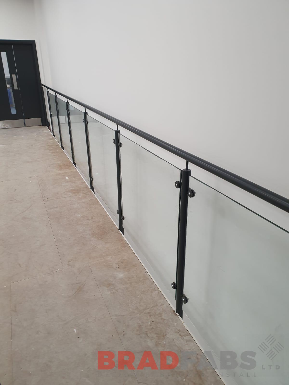 A view from on the mezzanine looking outwards, mild steel and powder coated balustrade with glass infill panels by bradfabs