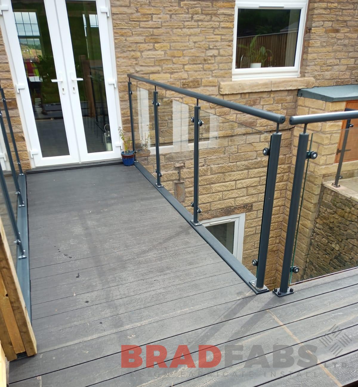 bespoke bridge, with mild steel, galvanised and powder coated balustrade with glass infill panels, complete with composite decking by bradfabs 